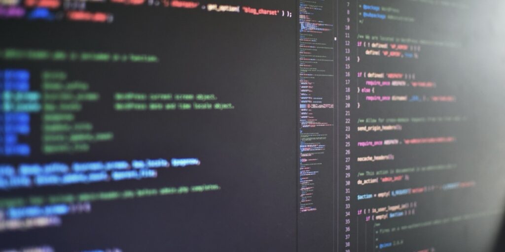 デュアルモニターに向かいコーディング作業を行う様子
