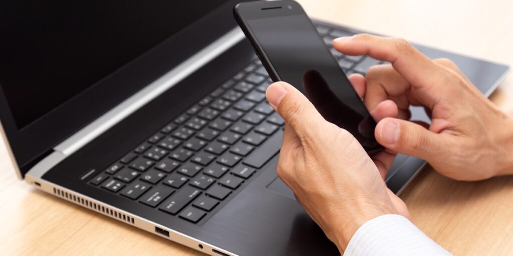 パソコンとスマートフォンで表示崩れがないかチェックしている様子